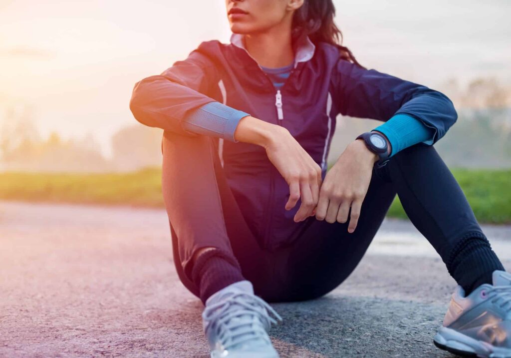 Runner sitting on the ground thinking about gentle nutrition 